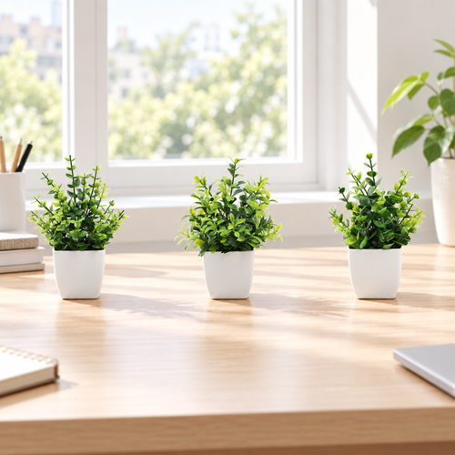 Lifestyle illustration of three compact faux green plants in white pots on a wooden desk