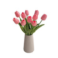 Pink faux tulip bouquet arranged in a vase on a white background